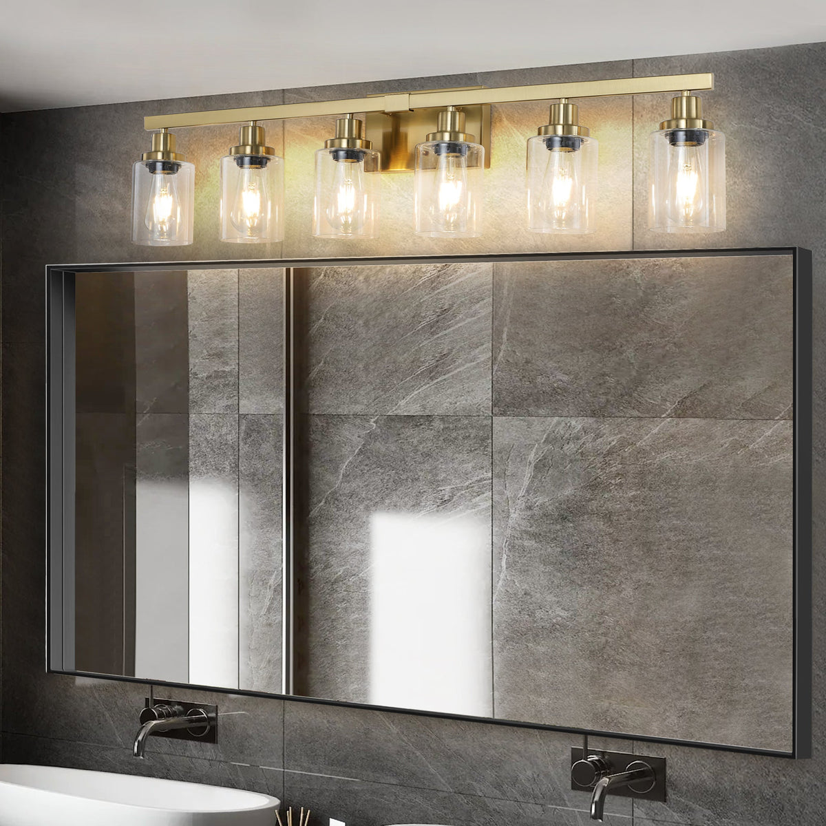 Six-light gold vanity fixture with clear glass shades in bright bathroom